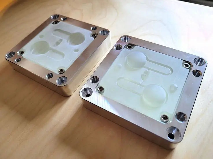 Close-up image of an injection mold partially open, revealing a plastic prototype part inside, highlighting mold complexity and production readiness.